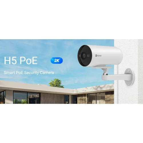 Na zdjęciu znajduje się biała kamera bezpieczeństwa Ezviz H5 PoE zamontowana na ścianie budynku, z widocznym niebieskim logo "2K" i napisem "Smart PoE Security Camera". W tle widać fragment nowoczesnego budynku oraz błękitne niebo z chmurami.