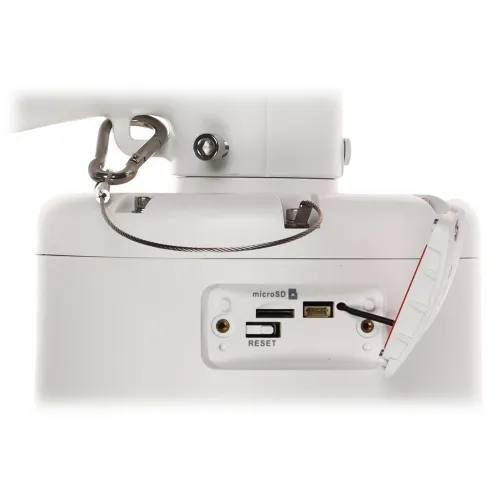 Zdjęcie przedstawia białe urządzenie z otwartą klapką, odsłaniającą gniazdo na kartę microSD, port USB oraz przycisk reset. W tle widoczny jest metalowy uchwyt z karabińczykiem i stalową linką zabezpieczającą.