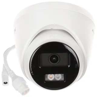 Biała kamera IP Hikvision z czarnym panelem frontowym, wyposażona w obiektyw i diody LED. Obok kamery znajdują się dwa białe kable połączeniowe.