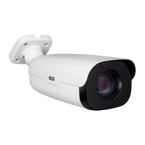 Biała kamera IP tubowa z czarnym obiektywem i logo BCS na obudowie. Kamera jest zamontowana na białym uchwycie ściennym.