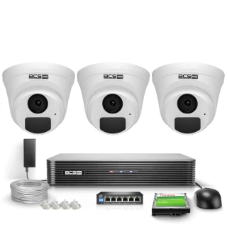 Na zdjęciu znajduje się zestaw monitoringu IP BCS Basic, składający się z trzech białych kamer kopułkowych, rejestratora, kabla, switcha oraz dysku twardego. Elementy są ułożone na białym tle, prezentując kompletny system do nadzoru wizyjnego.