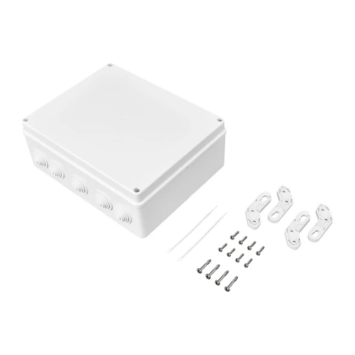 Biała, prostokątna obudowa zewnętrzna z zaokrąglonymi krawędziami, posiadająca kilka otworów na przewody. Obok obudowy znajdują się akcesoria montażowe, takie jak śruby, uchwyty i opaski zaciskowe.
