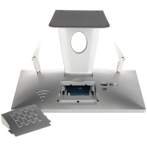 Na zdjęciu znajduje się urządzenie z kieszenią na dysk SATA 2,5 cala, umieszczone na podstawie z dwoma antenami po bokach. Obok urządzenia leży zdjęta pokrywa, a na podstawie widoczne są porty USB i przyciski.