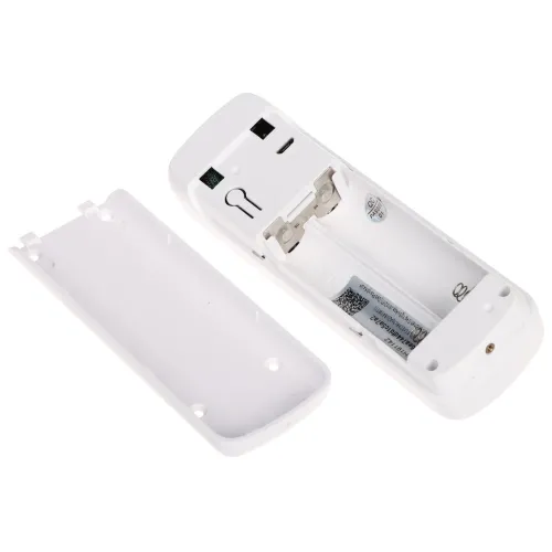 Zdjęcie przedstawia tylną część pilota z otwartą klapką, ukazującą miejsce na baterie. Wewnątrz widoczne są metalowe styki oraz miejsce na dwie baterie AA.