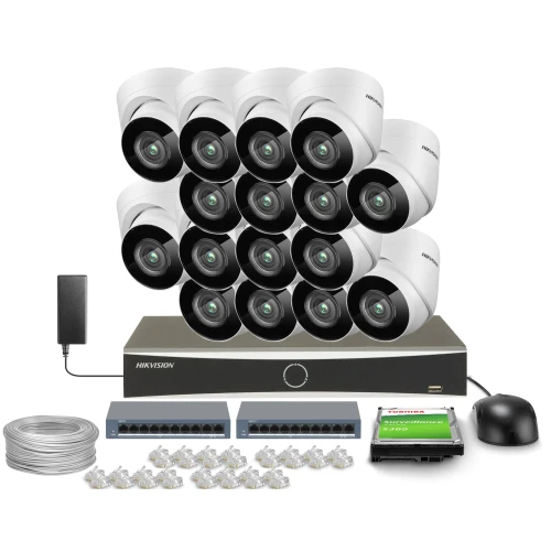 Zestaw do monitoringu składający się z szesnastu kamer, rejestratora, dysku twardego, zasilacza, kabla, dwóch switchów oraz złączek. Kamery są białe i ułożone w dwóch rzędach nad rejestratorem.